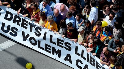 Protesters walk behind a banner reading 'In favour of rights and freedoms. We want you at home', referring to the jailed separatist leaders. AFP/Josep LAGO