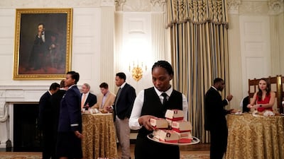 A server places fast food hamburgers on a plate. Reuters