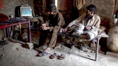 Miners on a break watch TV in a room at a coal field in Choa Saidan Shah, Punjab. Sara Farid / Reuters