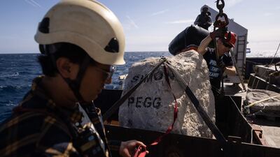 A limestone boulder with actor Simon Pegg's name on it, is prepared before being dropped into the sea. AFP