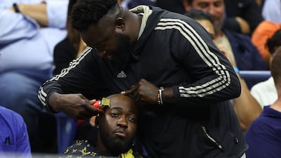 A fan gets his hair cut during the quarter-finals match between Nick Kyrgios of Australia and Russia's Karen Khachanov at the 2022 US Open at Arthur Ash stadium in New York. Getty Images / AFP