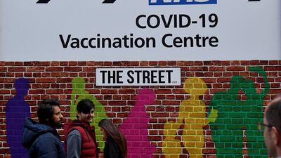 People walk past a sign for a Covid-19 vaccination centre amid the easing of lockdown restrictions in London. Reuters