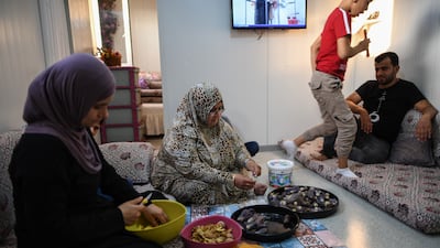 Rasha Yousuf, centre, and Affat Iskendro, left, prepare vegetables to make pickles in their home at the camp. Getty Images