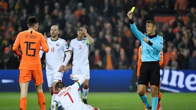 Netherlands' Marten de Roon is shown a yellow card by referee Davide Massa. Reuters