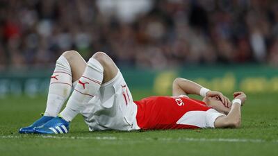 Arsenal’s Mesut Ozil lies on the pitch. Eddie Keogh / Reuters