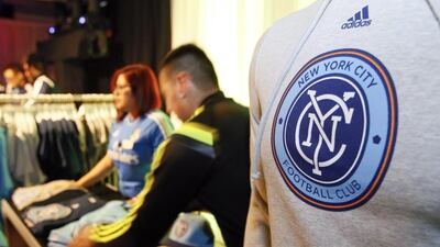 Sales people arrange team merchandise as they begin sales after the new MLS franchise New York City Football Club unveiled their new team badge in New York. New York City Football Club / Ray Stubblebine / AP Photo