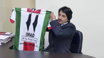 Roberto Kettlun, sports manager for Deportivo Palestino, holds up a football shirt with the map of Palestine replacing the 1's. Juman Jarallah / The National 