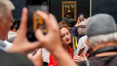 People take photos of Leonardo da Vinci's Mona Lisa painting at the Louvre museum in Paris. AP