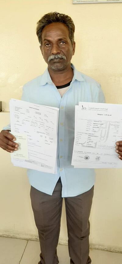 Durgaiah Dobbali, a construction worker, shows the official papers that allowed him to return to his family in India. Girish Pant