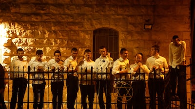 Ultra Orthodox Jews watch at the scene of the attack. Reuters