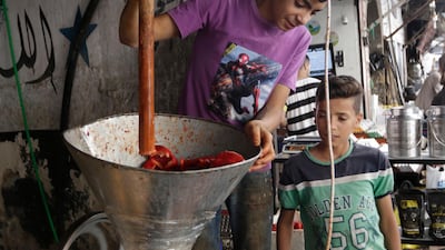 A Syrian boy prepares red chillis to make Makdous in the old market of Bab al- Sreijah in Damascus, Syria. EPA