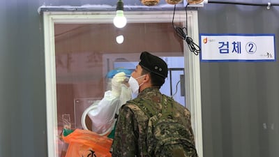 A medical worker takes a nasal sample from a soldier at a coronavirus testing site in Seoul, South Korea. AP