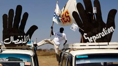 A supporter of the referendum on southern independence adjusts a banner on top of a car during a rally in Juba.