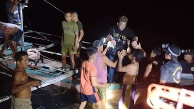 Locals help people disembark the burning boat. AFP