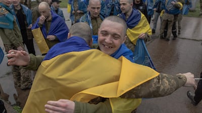 Freed Ukrainian prisoners draped in their national flag, in the Chernihiv region on Friday. AFP