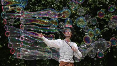 A street artist blows bubbles during a performance in Paris, as a heatwave sweeps across much of France and Europe. AFP