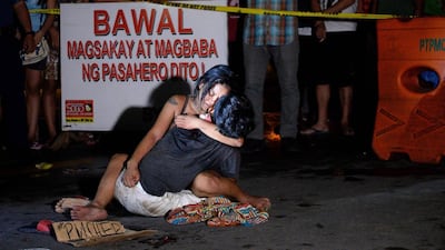 Jennilyn Olayres hugs the body of her partner Michael Siaron who was murdered by a gunman and left with a cardboard sign with a message “I’m a pusher” in a street in Manila. Noel Celis / AFP