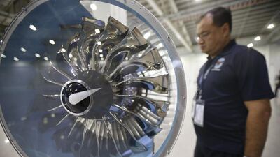 An engineer examines a small model mock up of the Pratt & Whitney geared turbofan engine on display at a manufacturing plant in Singapore. Wallace Woon / EPA