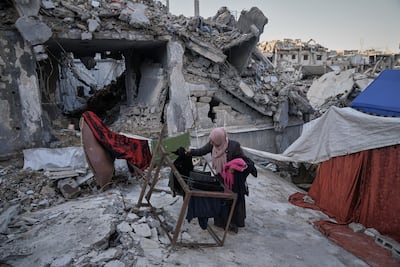 A woman hangs out laundry beside a tent in the ruins of her family's home in Gaza city's Sheikh Radwan neighbourhood. AP