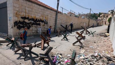 Children walk on a blocked road after an Israeli military raid in Jenin on Monday. AFP