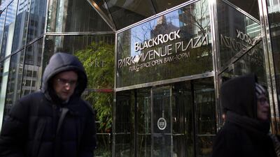 Pedestrians pass in front of BlackRock offices in New York. The company has seen earnings disappoint. Bloomberg