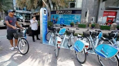 Abdulaziz Abdullah, left, executive manager of Byky, and Miroslaw Szibas, of NextBike, demonstrate how to use a bicycle rental station, which can be found at key sites such as Burj Khalifa and Marina Mall. Sarah Dea/The National