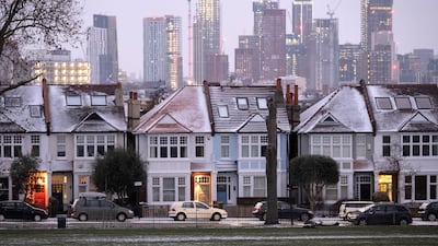 Snow-covered roofs in South London homes sit in front of high-rise towers under construction. House buyers now favour houses over apartments following the pandemic to meet their demand for more space. Getty Images