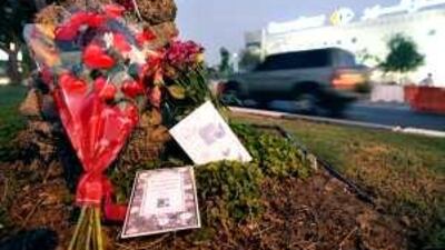 Flowers and cards are seen on Airport Road on July 1 near the spot where three sisters were fatally struck by a car on the night of June 29.