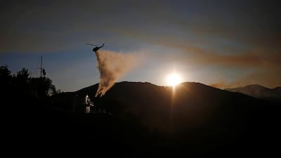 A helicopter drops water as the Woolsey Fire continues to burn in Malibu. Reuters