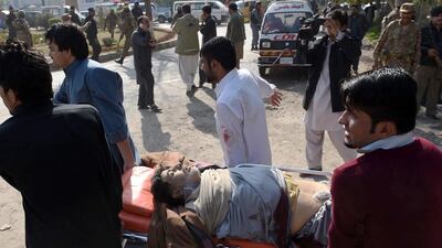 Pakistani volunteers move an injured worshipper near a Shiite Muslim mosque in Peshawar after an attack by Taliban militants on February 13, 2015. A Majeed/AFP Photo