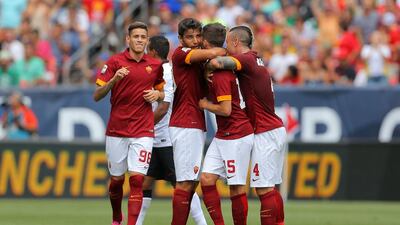 Miralem Pjanic, second right, of AS Roma is hugged by teammates Antonio Sanabria, left, Michele Somma, second left, and Radja Nainggolan, right, after scoring a 60-plus yard goal against Manchester United on Saturday in the International Champions Cup. Justin Edmonds / Getty Images/ AFP