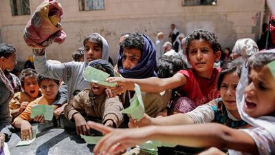 In this April 13, 2017 photo, Yemenis present documents in order to receive food rations provided by a local charity in Sanaa, Yemen. Hani Mohammed / AP
