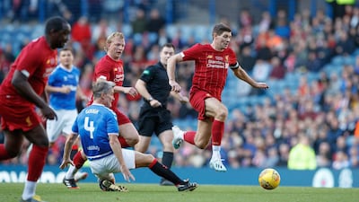 Liverpool great Steven Gerrard jumps clear of Rangers' Richard Gough during the legends match at the Ibrox Stadium in Glasgow. Press Association