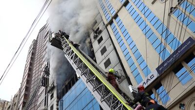 People are seen being rescued as fire broke out at a multi-storey commercial building in Dhaka. Reuters