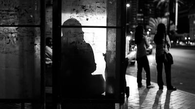 At the end of the evening workers in the downtown of Abu Dhabi await busses to make their way home. Brian Kerrigan / The National.