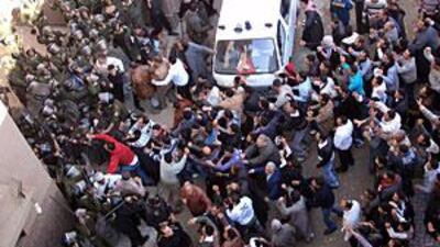 Egyptian riot police stand guard during clashes outside a morgue, where the bodies of the six Christians killed the previous day are kept.