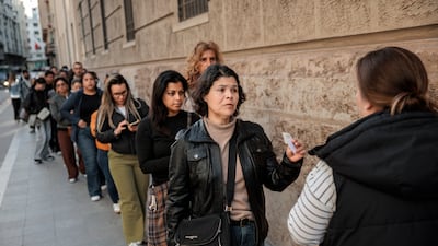 Migrants line up outside the municipal registry office in Valencia, Spain. EPA
