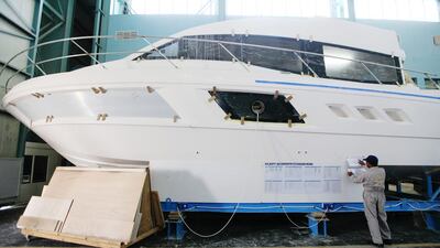 A worker consults a work order in the production warehouse at the Gulf Craft factory. Sarah Dea / The National