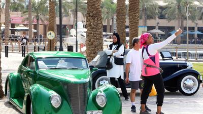 A woman takes a selfie with a 1937 Ford at a classic car show in Kuwait City. All photos by AFP