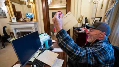 A supporter of US President Donald Trump at a desk in the office of US House Speaker Nancy Pelosi, after supporters of the president breached the US Capitol security in Washington, DC. EPA