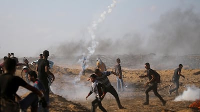 Palestinians react as tear gas was fired by Israeli troops during a protest at the Israel-Gaza border in the southern Gaza Strip on July 13. Reuters