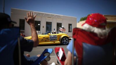 People wave at a car during the annual fiesta parade in Truth or Consequences, New Mexico. Lucy Nicholson / Reuters