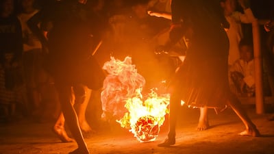 TOPSHOT - Indonesian Muslim children wearing traditional sarongs play fireball football, known locally as Sepak Bola Api, as part of celebrations marking the beginning of the Islamic New Year in Bandung, West Java on June 26, 2025. (Photo by TIMUR MATAHARI / AFP)