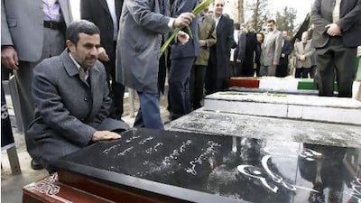 Iranian President Mahmoud Ahmadinejad prays at the grave of Gen Hasan Tehrani Moghaddam, a Revolutionary Guard commander, who was in charge of the country's missile programme and was killed in an explosion at an ammunition depot in November 2011, in a ceremony commemorating 33rd anniversary of Iran's 1979 Islamic Revolution on Saturday. Vahid Salemi / AP