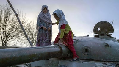 In Kandahar, where playgrounds are largely unavailable, children play on an old Soviet tank. Conflict is all-present in the southern province and eighteen years of American invasion haven't defeated the Taliban. Photo by Stefanie Glinski