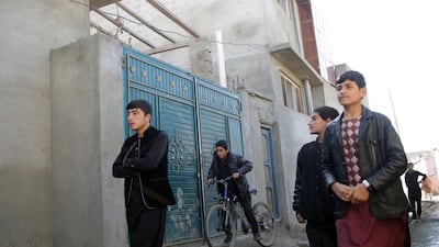 Residents of the Qala-e-Walid neighbourhood of Kabul walk past the house used as a hideout by ISIL on February 2, 2018. Massoud Hossaini / AP Photo