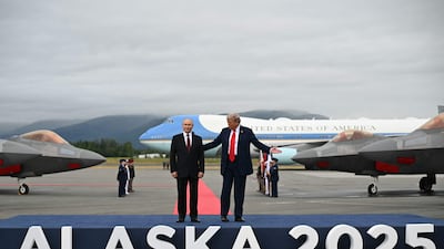 Mr Trump and Mr Putin pose on a podium on the tarmac after they arrived at Joint Base Elmendorf-Richardson in Anchorage. AFP
