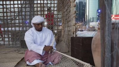 A participant demonstrates a traditional method of weaving a fishing net. Christopher Pike / Crown Prince Court — Abu Dhabi