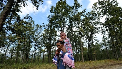 Chandra Bahadur Dangi (C), a 72-year-old Nepali who claims to be the world's shortest man at 56 centimetres (22 inches) in height, is carried by his nephew Tilak Dangi on the way to his home village in Dang district, some 540 kilometres southwest of Katha???