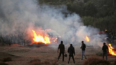 Palestinian protesters take cover from Israeli tear gas during a protest against Donald Trump's decision on Jersualem. Mohammed Saber / EPA